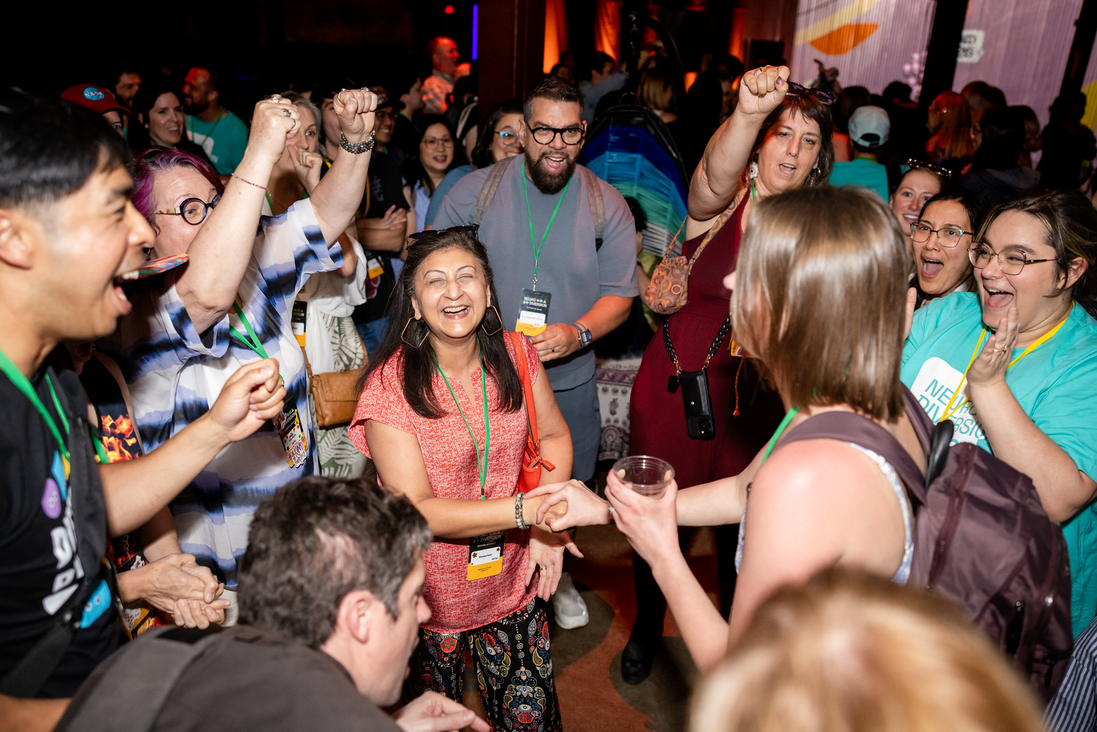 NeuroDiversion attendees laughing and cheering with raised fists at the annual gathering in Austin