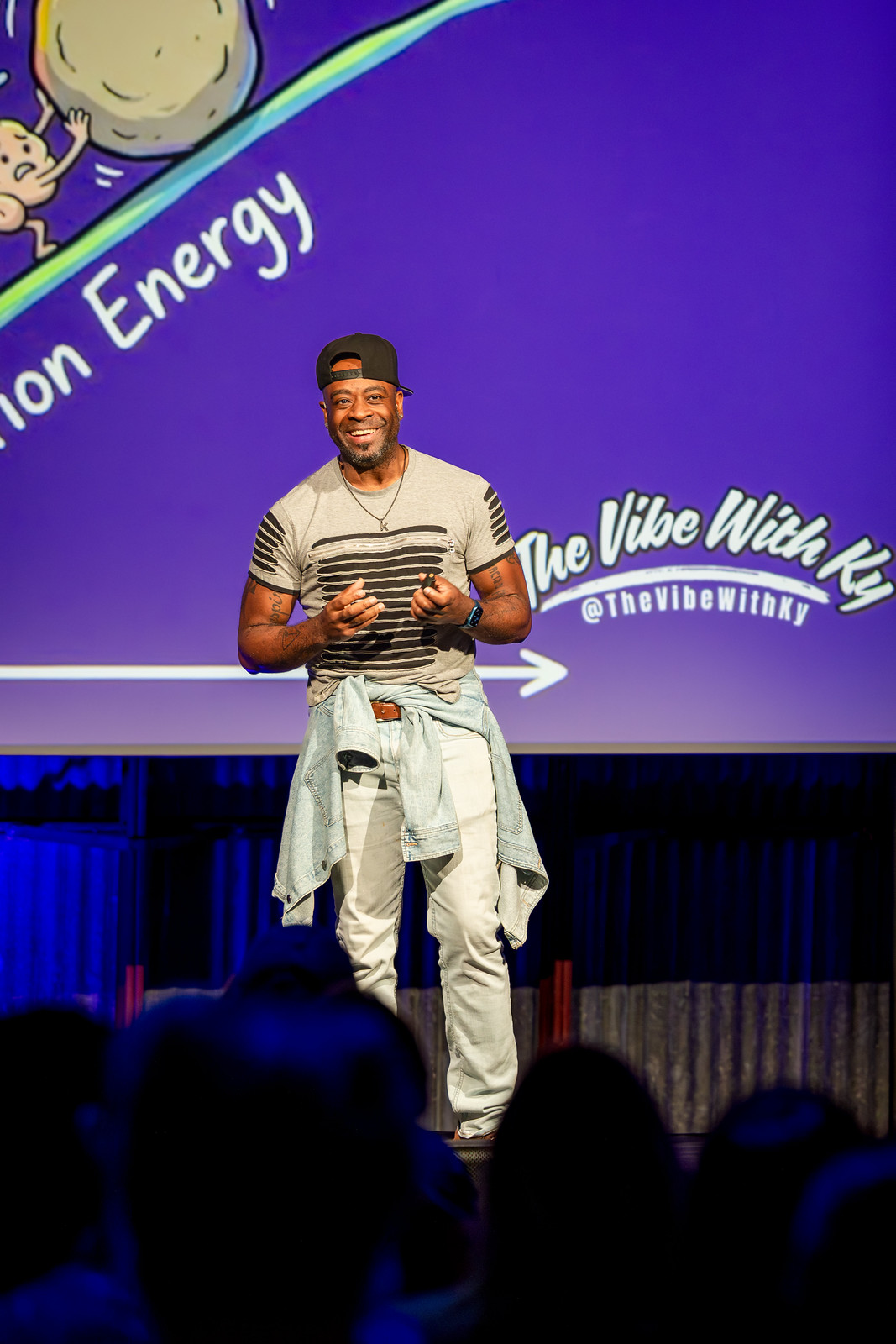 Ky Westcott smiling on the NeuroDiversion 2026 main stage, with The Vibe With Ky logo on the screen behind him